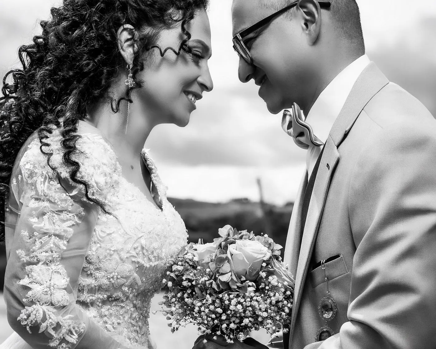 Novios frente a frente con ramo, fotografía en blanco y negro